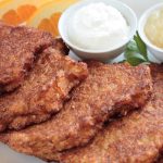 Langer's latkes on a plate with side dishes