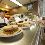 freshly made sandwiches line the server's counter