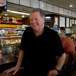 Norm posing at the deli counter