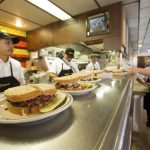 freshly made sandwiches line the server's counter