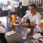 4 people sitting in a deli booth chatting