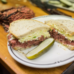 pastrami sandwich with swiss cheese and cole slaw on rye bread