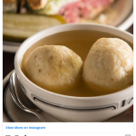 2 large dumplings floating in a bowl of broth