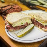 pastrami sandwich garnished with dill pickle