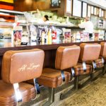 seats along the counter in a delicatessen